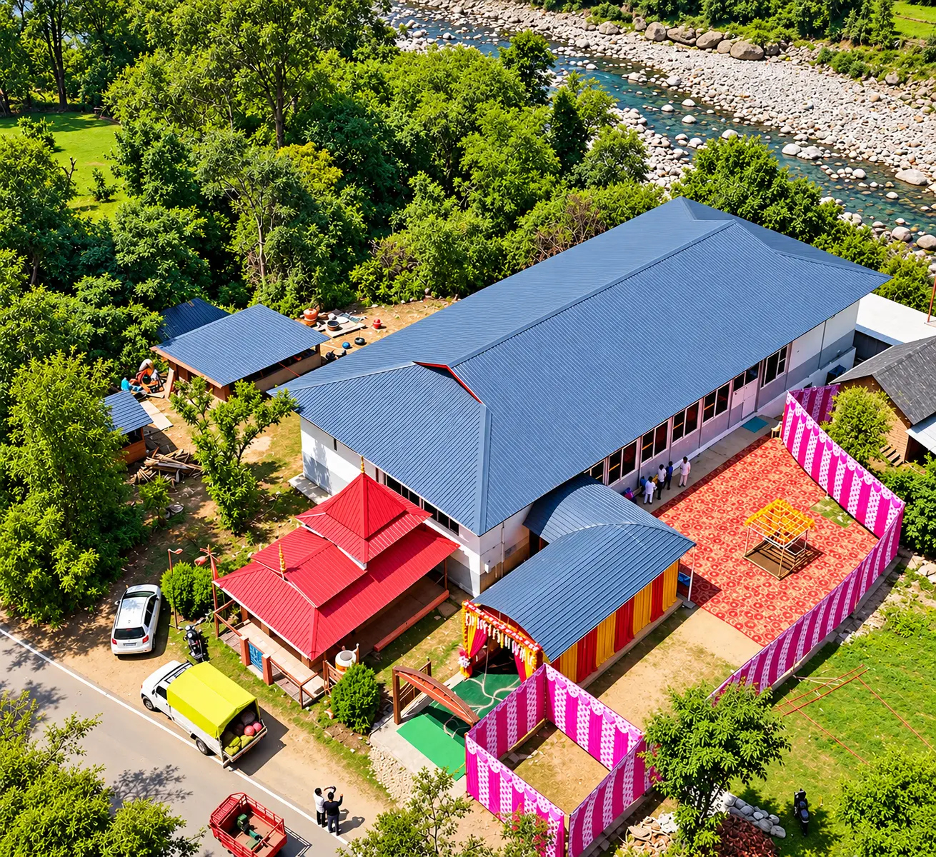 Aerial view of Ved Banquet Hall decorated for an event, with the red-roofed pavilion, draped entrance and courtyard beside the river